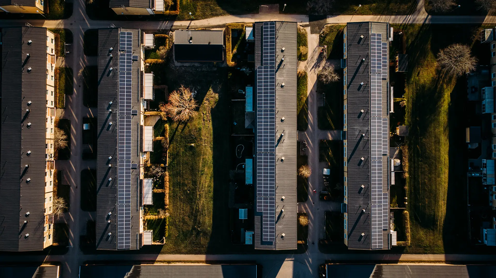 Flygbild på fyra hus längor som alla har solceller på taken. Husen tillhör Riksbyggen BRF Västerängen i Västerås