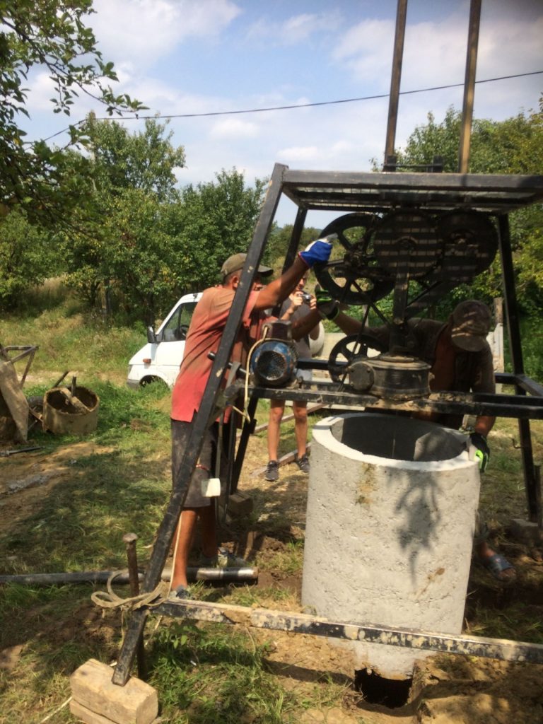 En man vid en vatten brunn i Rumänien