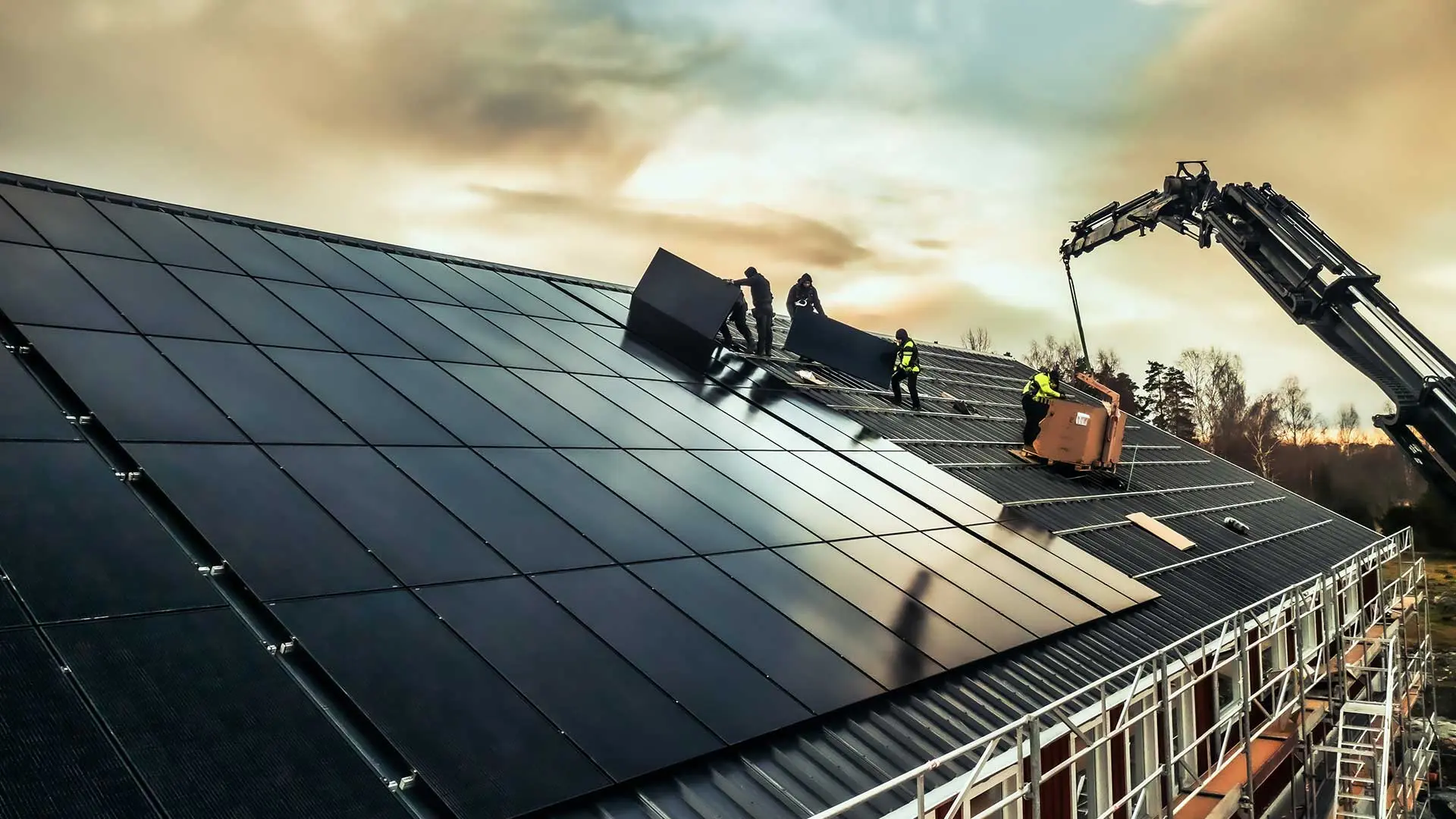 Människor monterar solceller på ett tak i Västerås