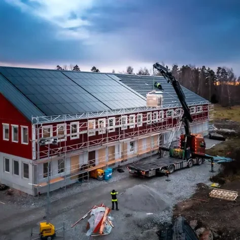 Huawei Solpaneler lyfts upp med kranförare till ett tak
